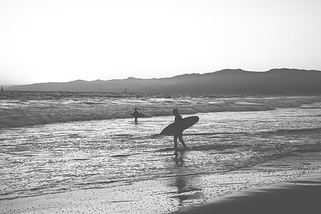 two people holding surfboards at beach thumbnail