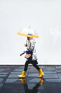 person walking on sidewalk holding umbrella during day time thumbnail