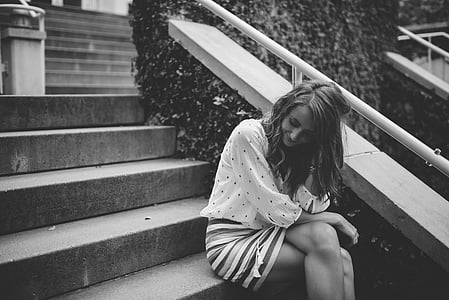 grayscale photo of woman sitting on stairs thumbnail