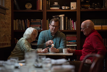 three person in front of white wooden table inside room thumbnail