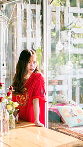 Woman Wearing Red Shirt Standing Near Table thumbnail