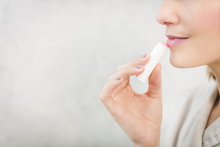woman holding lip balm thumbnail