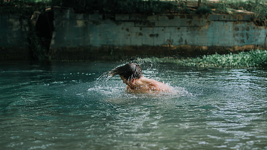 man swimming during daytime thumbnail