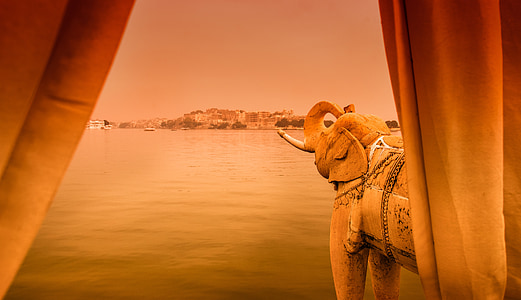 brown elephant behind brown curtain facing brown hill thumbnail