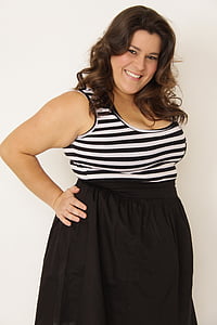 smiling woman posing near wall thumbnail