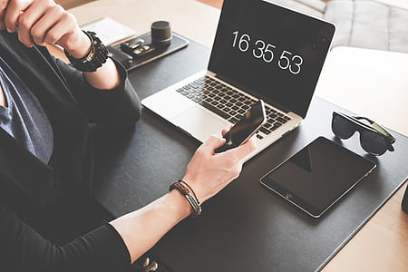 Woman Using a Smartphone While Fronting a Macbook Pro and Black Ipad thumbnail