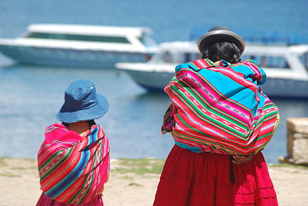 woman and child wearing red dress facing body of water thumbnail
