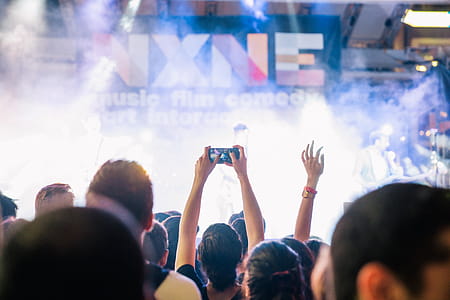A view of concert audience from crowd with smoky stage in the background thumbnail