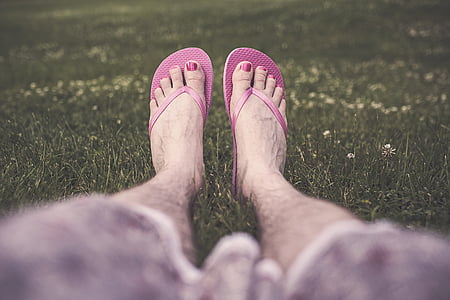 person wearing rubber flip-flops sitting on grasses thumbnail