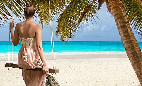 woman sitting on swing watching seashore thumbnail