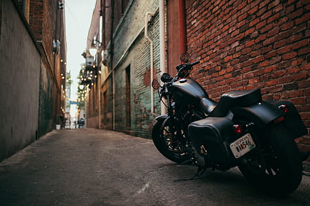 black cruiser motorcycle beside the building thumbnail