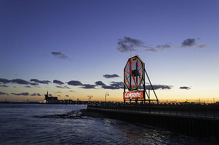 Colgate signage near body of water thumbnail