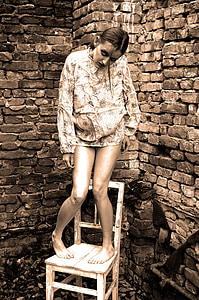 woman wearing pullover while standing on chair thumbnail