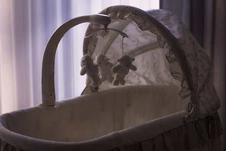 baby's white bassinet beside curtain thumbnail