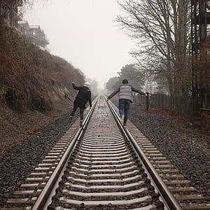 man and woman stepping on railroad thumbnail