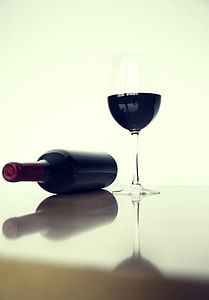 black wine glass beside black bottle thumbnail