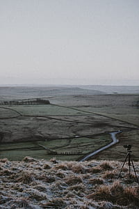 camera setup on top of the cliff overlooking the road and grass field thumbnail