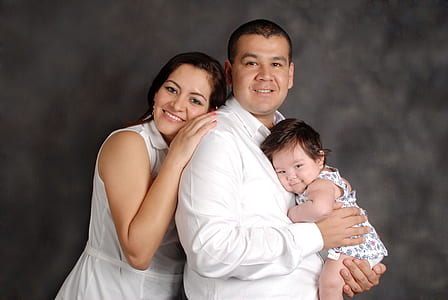 photo of woman leaning on back of man that carrying a baby thumbnail