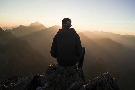 silhouette photography of person sitting on top of mountain thumbnail