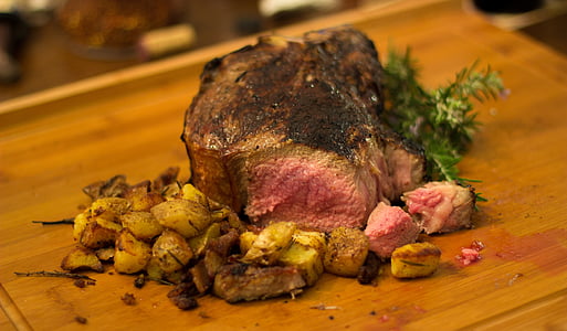 sliced piece of meat on brown surface topped with vegetables thumbnail