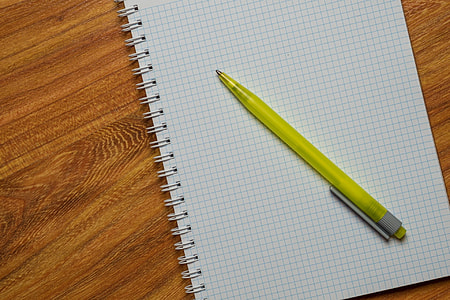 yellow click pen on top of white graphing paper thumbnail