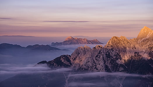 aerial photo of brown mountain surrounded by clouds thumbnail