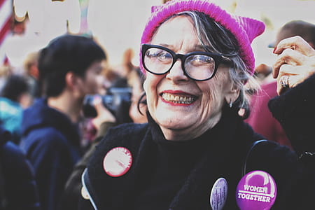 woman wearing knit cap and eyeglasses beside man taking a picture thumbnail