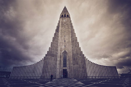 grey cathedral under cloudy sky in sepia mode photo thumbnail