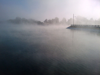 shallow photography of body of water covered with fog thumbnail