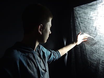 man wearing pullover top peeking inside dark room thumbnail