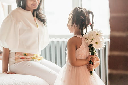 Daughter About To Suprise Mom With Flowers Photo thumbnail