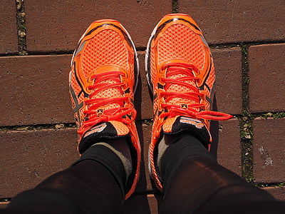 closeup photo of person wearing orange-and-black running shoes thumbnail