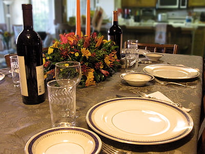 white plates on table near bottle thumbnail