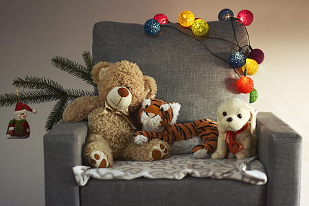 brown bear, tiger, and dog plush toys on black sofa chair thumbnail
