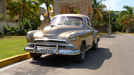 classic beige sedan parked near yellow concrete gutter at daytime thumbnail