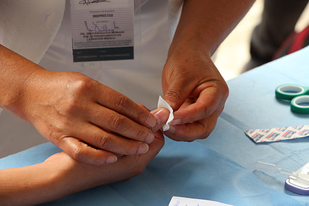 person stopping thumb finger blood with white paper during daytime thumbnail