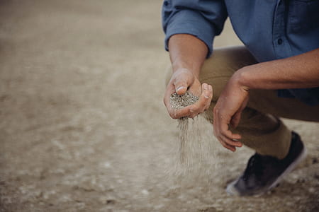 man holding gray sands thumbnail