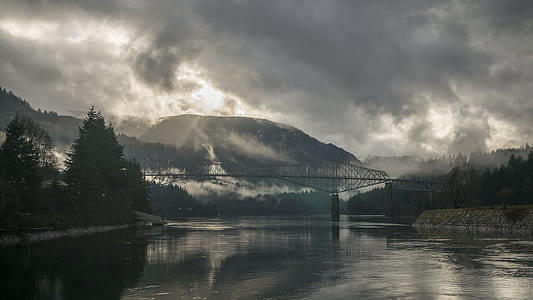 photo of grey metal bridge under cloudy sky thumbnail