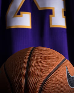 orange Nike basketball near purple and white jersey thumbnail