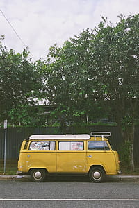yellow van parked near tree during daytime thumbnail