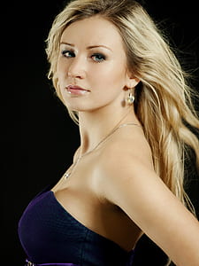 photo of woman wearing blue sweetheart neckline dress with black background thumbnail