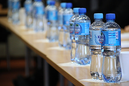 pile of water bottle on rectangular brown wooden table thumbnail