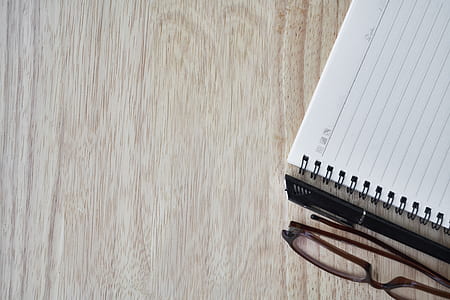 white notebook near black framed eyeglasses thumbnail
