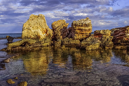 rocks on beach under gray sky thumbnail