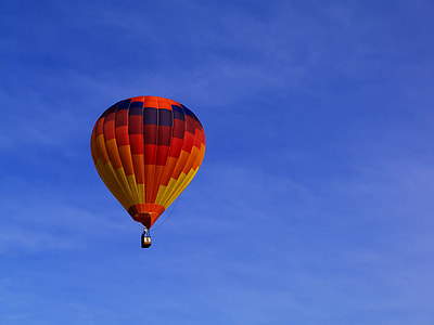 red, orange, and yellow hot air balloon in the sky under blue sky thumbnail