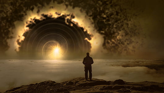 man standing on brown cliff thumbnail