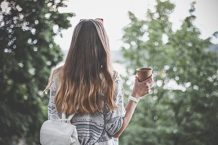 selective focus photograph of woman holding cup thumbnail
