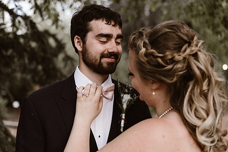 woman fixing man's pink bow tie thumbnail