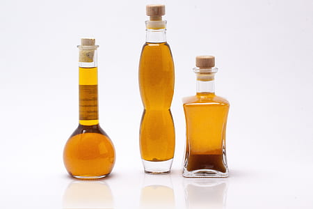 three olive oils on clear glass bottles thumbnail