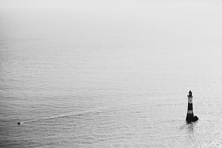 lighthouse at the middle of the ocean during day time thumbnail